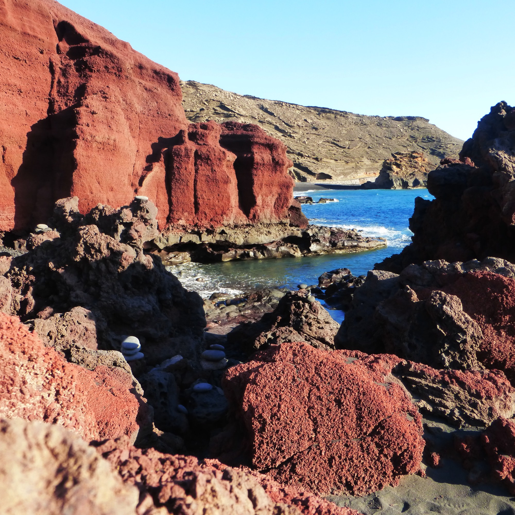 Küste im Westen der Insel: Rote Lava, schwarzer Sand