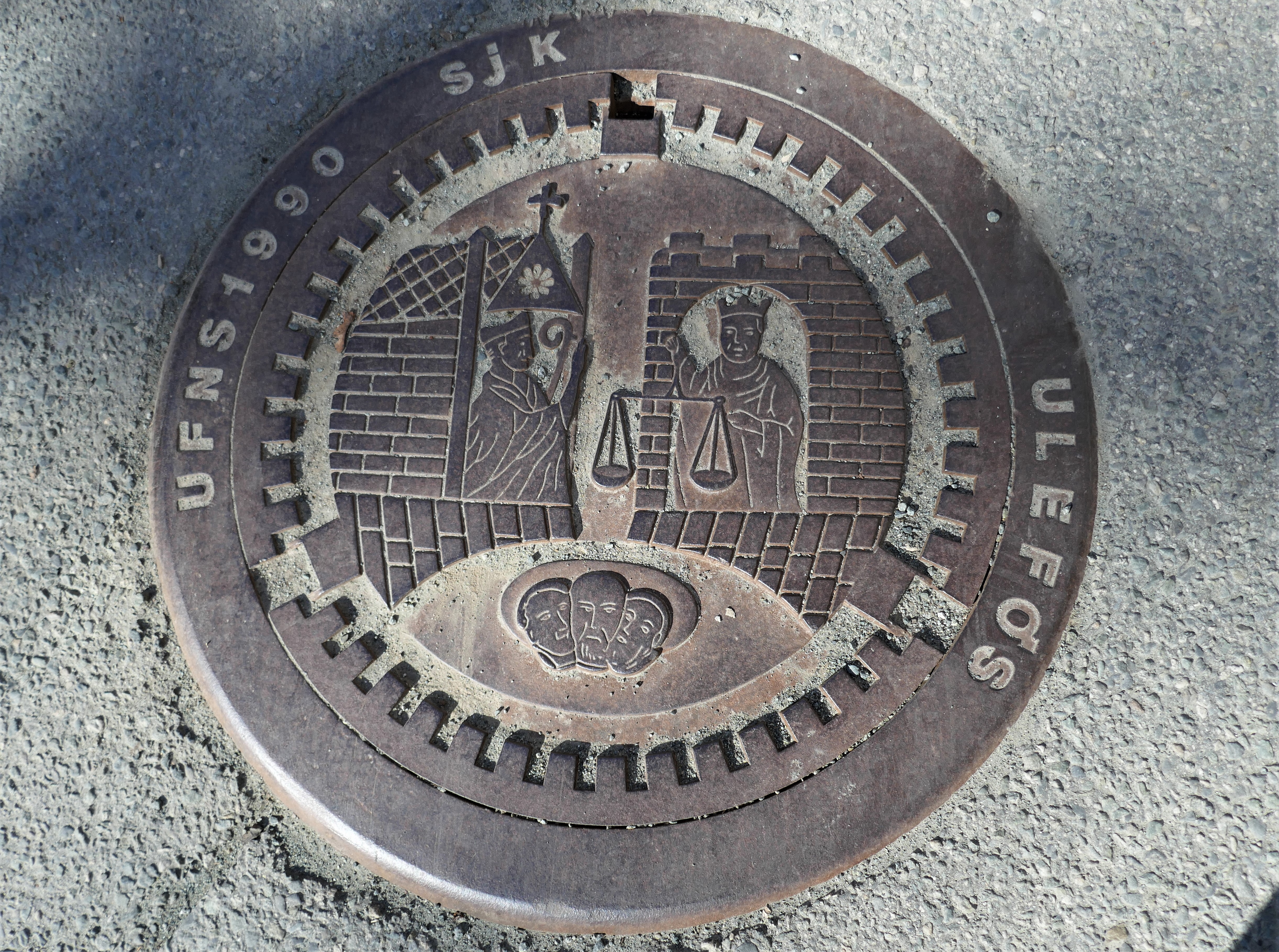 Der Kanaldeckel offenbart den Schwerpunkt der Stadt